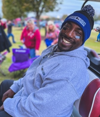 Black man smiling while sitting in a caddy