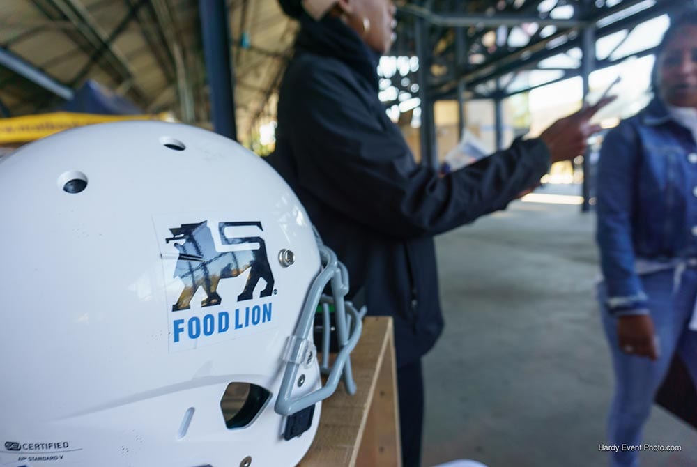 Woman beside a food lion helmet